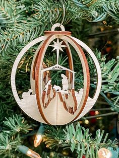 an ornament hanging from a christmas tree with nativity scene in the center