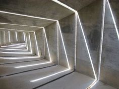 an empty concrete tunnel with light coming through it