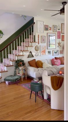 a living room filled with lots of furniture and pictures on the wall next to stairs