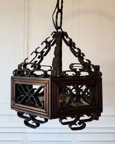 a chandelier hanging from the ceiling with an intricate design on it's sides