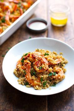 a white plate topped with shrimp and couscous next to a pan of food