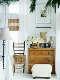 an image of a room with furniture and pictures on the wall, including a dresser