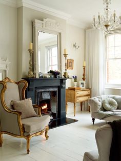 a living room filled with furniture and a fire place next to a mirror on the wall