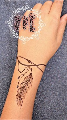 a woman's arm with a tattoo on it that has a feather and beads hanging from it