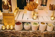 an assortment of different types of food on display in front of a sign that says dips for sticks