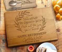 a wooden cutting board with the words happy retirement written in cursive writing on it