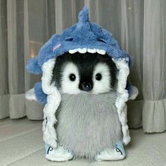 a stuffed animal that is wearing a blue and white hat with a shark on it's head