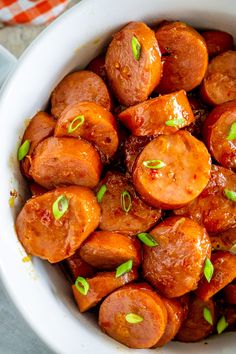 a white bowl filled with cooked carrots on top of a table