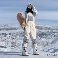 a snowboarder is standing on top of a mountain with his board in hand