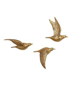 three gold birds flying in the air