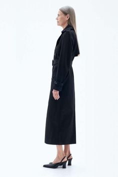 The trench coat has a slim fit and full length in black organic cotton twill with a water-repellent finish. detailed with a double breasted closure and belted waist. wear it on cool or rainy days in the transitional months.    size & fit    - ankle length  - slim fit  - model is 180cm / 5.9" and is wearing a size 36  -    details    - shoulder epaulettes  - back yoke  - removeable belt  - buckled sleeve straps  - slanted welt pockets  - back vent  - fully lined  - made in: lithuania  - lining: 54% polyester (mech. recycled) 46% viscose  - shell: 100% cotton (organic) Sleeve Straps, Cotton Trench Coat, Shoulder Epaulettes, Trench Coat Black, Blue Flats, Engineered Garments, Rainy Days, Welt Pockets, Ankle Length