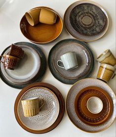 a table topped with plates and cups filled with different types of saucers on top of each other