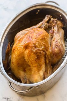 a roasted chicken in a pot on a counter top with the lid open to show it's skin