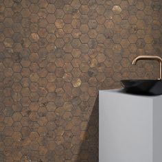 a black sink sitting on top of a white pedestal next to a wall mounted faucet