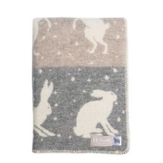 a blanket with animals on it and snowflakes in the background, as well as an image of a dog