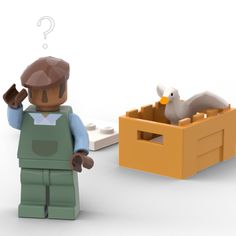 a lego man standing next to a box with a duck in it