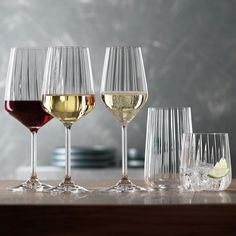 four wine glasses with different wines in them