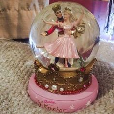 there is a snow globe with a man and woman in it on the floor next to a couch