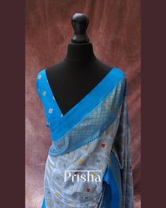 This grey saree features bandhani print on Pashmina silk, accented by a striking blue contrast border. Expertly crafted using the perfected hand block printing technique, the border of the saree narrates the timeless stories of rural villagers from centuries past. The saree is completed with elegant blue tassels. Blouse: Blue bandhani printed Pashmina silk [unstitched] Please note, slight color variations may occur due to lighting. please send us a message if you want blouse material separated Blue Jamawar Pre-draped Saree With Zari Weaving, Blue Tussar Silk Pre-draped Saree With Dupatta, Blue Silk Traditional Wear With Printed Border, Transitional Blue Silk Pre-draped Saree, Blue Banarasi Silk Traditional Wear With Printed Border, Blue Katan Silk Dupatta With Printed Border, Unstitched Blue Saree With Border, Blue Bollywood Dupatta With Border, Blue Saree With Printed Border For Festivals