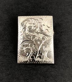 This is a lovely estate sterling silver rectangular domed pin brooch featuring an engraved floral, botanical, Art Nouveau design. It has a functional roll over catch. The pin is hallmarked STERLING and tests positive for sterling silver with the 18K acid solution (video of testing is available upon request, prior to purchase). A partial maker's mark is also visible. Valentine's Day gift. Weight: 4.27 G Length: 1.23" (3.1 cm) Width: 0.89" (2.26 cm) Very good estate preowned condition (see photos, Silver Engraved Heirloom Brooches, Silver Heirloom Engraved Brooches, Collectible Engraved Silver Brooch, Classic Silver Engraved Brooches, Classic Engraved Silver Brooches, Silver Engraved Brooches For Formal Occasions, Succession Style, Black Patch, Art Nouveau Design