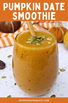 pumpkin date smoothie in a glass with a wooden spoon on the side and an orange striped napkin behind it