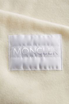 a white label that says moncler on the side of a shirt with an embroidered name