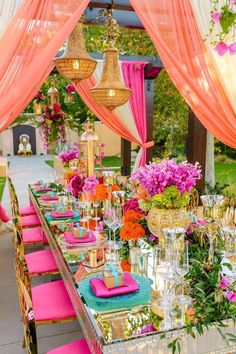 a long table covered in lots of pink and orange flowers