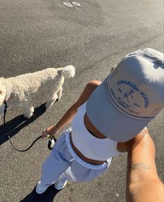 a person holding a dog on a leash and walking it down the street with another person