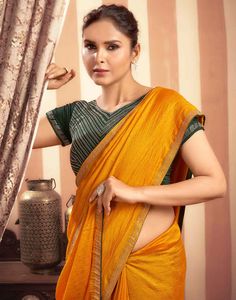 Turmeric Yellow Stone Work Embellished Silk Saree  Turmeric Yellow Stone Work Embellished Silk Saree is a luxurious and elegant piece. The rich silk fabric drapes beautifully, creating a flowing and sophisticated look. The intricate stone work, which can feature floral motifs, geometric patterns, or abstract designs, adds a touch of opulence and sparkle.  Features Of Turmeric Yellow Stone Work Embellished Silk Saree  Traditional Handloom Craft  Intricate Gold Brocade Work  Durability and Longevi Designer Yellow Slub Silk Blouse Piece, Elegant Orange Pre-draped Saree With Unstitched Blouse, Gold Slub Silk Saree Set, Designer Yellow Slub Silk Pre-draped Saree, Navratri Gold Slub Silk Lehenga, Designer Gold Slub Silk Blouse Piece, Gold Slub Silk Lehenga With Zari Work, Gold Slub Silk Lehenga For Navratri, Bollywood Orange Silk Pre-draped Saree