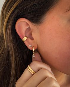 Our croissant ear cuff is elegance with edge and gives your earring stack a bold look. Add this stand-out piece to your earring stack and let the compliments roll in. How to place an ear cuff: Start by sliding the ear cuff over the top part of your ear ( the thinnest cartilage part) then slide down onto the lower conch. Gently tug to make sure it does not come off. Squeeze to tighten if necessary. Gold Plated Huggie Ear Cuff Single Earring, Minimalist Gold Plated Huggie Ear Cuff, Earring Stack, Gold Ear Cuff, Mini Studs, Gold Filled Hoops, Ear Cuff Earings, Hammered Gold, Diamond Charm