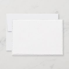 two pieces of white paper with torn edges on the bottom, and one piece of white paper in the middle