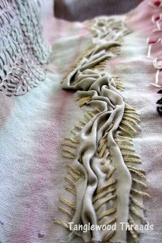 an embroidered piece of cloth with fringes on it