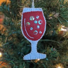 a wine glass ornament hanging from a christmas tree