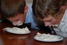 two young boys are eating cake together