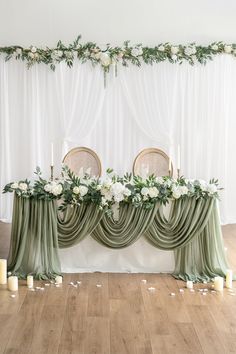 the table is decorated with greenery and white flowers