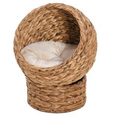 a cat bed made out of wicker with a white pillow in the center and bottom