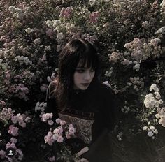 a woman sitting in the middle of flowers