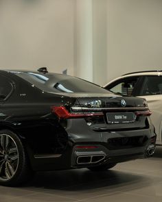 two bmw cars are parked in a showroom