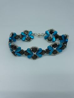 a blue and black bracelet with flowers on it