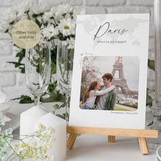 an easel holds a photo of two people in front of the eiffel tower