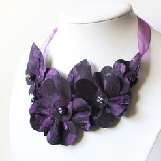 This elegant necklace is perfect for evening wear as the party season gets going. This purple flower ribbon necklace is perfect for anybody who is allergic to metals as it is completely fabric and felt based so there's no nasty reactions!  The necklace is sewn with black and purple glass and silver colour beads for a touch of sparkle. This purple floral necklace would be fabulous on New Years Eve if you are looking to make a statement!SIZE: Main flower detail roughly 16cm (roughly 6") across. Th Adjustable Handmade Flower Necklace For Party, Handmade Flower Necklaces For Party, Adjustable Handmade Flower Necklaces For Parties, Party Necklaces With Handmade Flowers, Handmade Flower Jewelry For Parties, Adjustable Flower Necklace For Party, Fabric Brooches, Fabric Brooch, Necklace Elegant