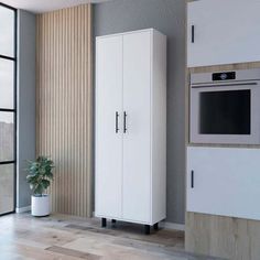 a white cabinet next to a window with a potted plant in front of it