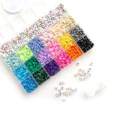 there are many different colors of beads in the box next to each other on the table