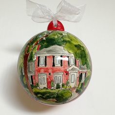 a glass ornament with a house painted on it's front and side