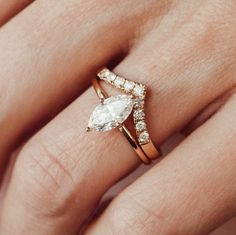 a woman's hand with a ring on it and a pear shaped diamond in the middle