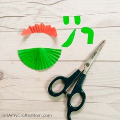 scissors, paper fan and other crafting supplies laid out on a white wooden surface