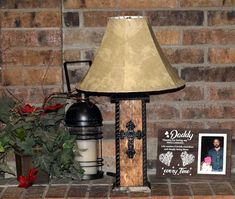 a lamp on top of a table next to a potted plant and photo frame