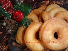 there are many doughnuts on the plate with pine cones and holly decorations around them