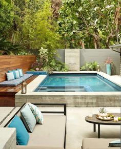 an outdoor living area with a pool and patio furniture in the foreground, surrounded by trees