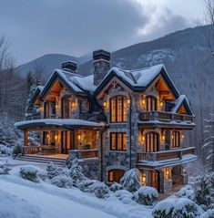 a large stone house surrounded by snow covered trees